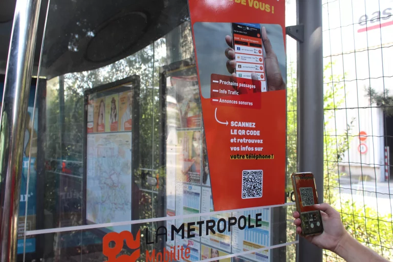 Un usager scanne un QR code sur un arrêt de bus